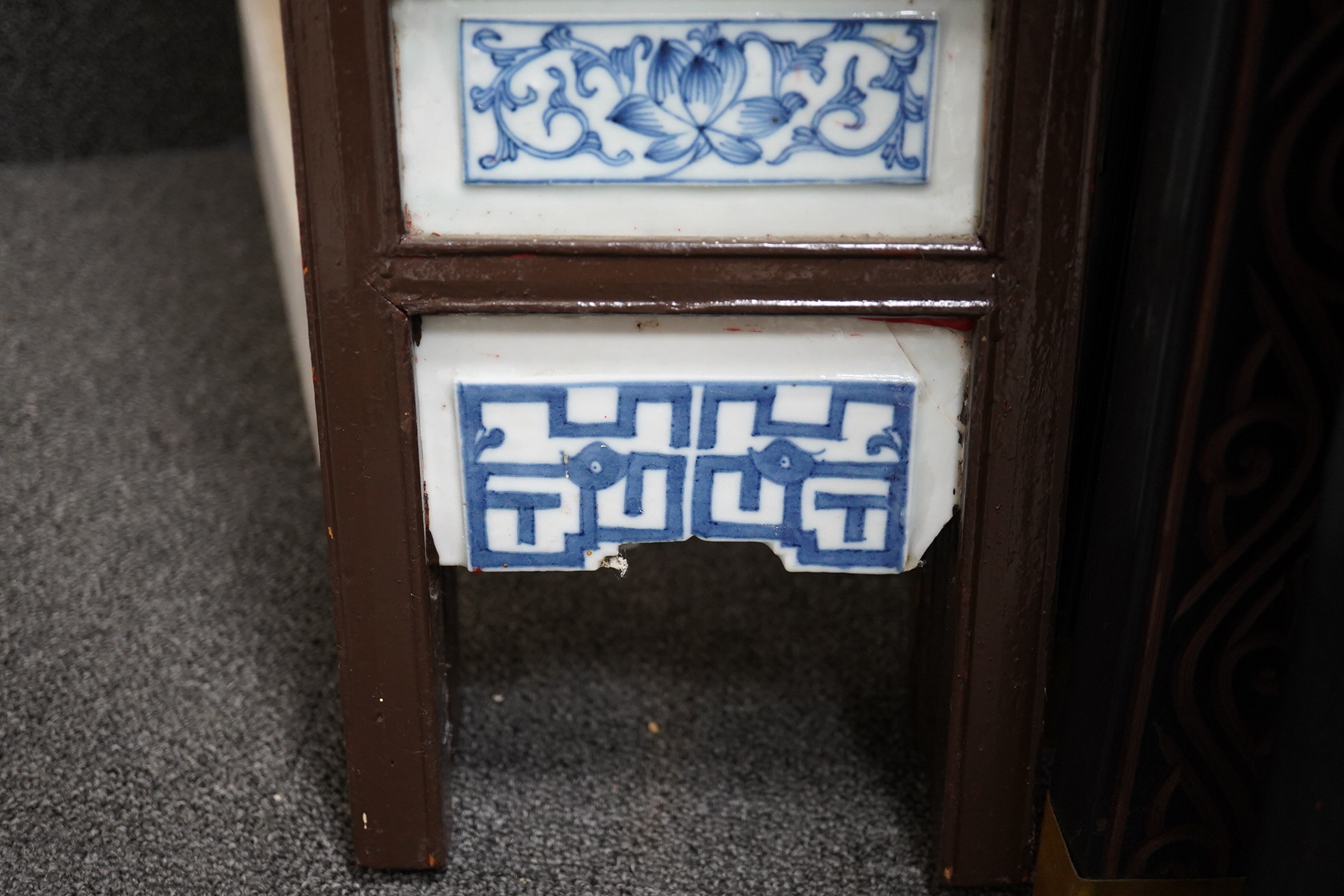 A Chinese wood framed and porcelain mounted low screen, late 19th century